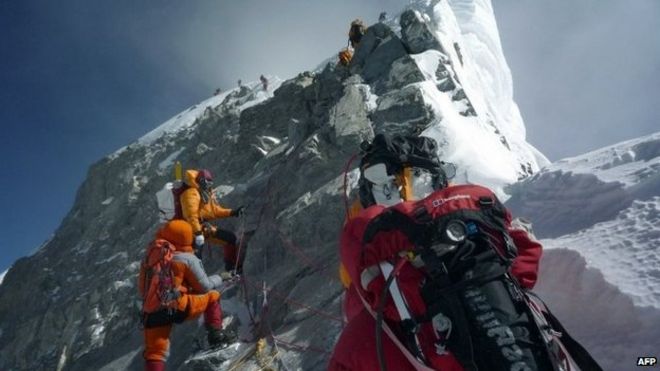 На этой фотографии, сделанной 19 мая 2009 года, неопознанные альпинисты проходят мимо Ступени Хиллари, продвигаясь к вершине горы Эверест, когда они поднимаются на юг из Непала