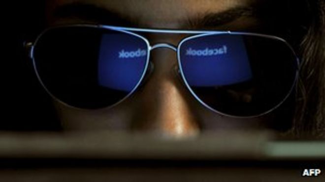 Логотип Facebook отражается в очках молодой индийской женщины
