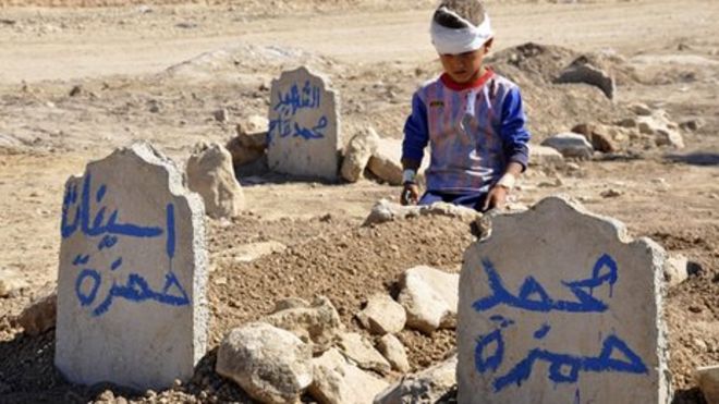 Осень 2013 года: Али Хамза, 8 лет, сидит у могил своего брата Мухаммеда и сестры Асинат