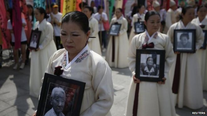 Участники несут портреты корейских женщин, которые были сделаны секс-рабынями японскими военными во время Второй мировой войны, во время церемонии панихиды по бывшей женщине, утешающей Ли Ли Ёнье, в центре Сеула, Южная Корея, 14 августа 2013 года Китай заявляет, что во время резни в Нанкине погибло около 300 000 человек - цифры, которые оспаривают японские националисты, " 76-я годовщина резни в Нанкине. Дек 2013
