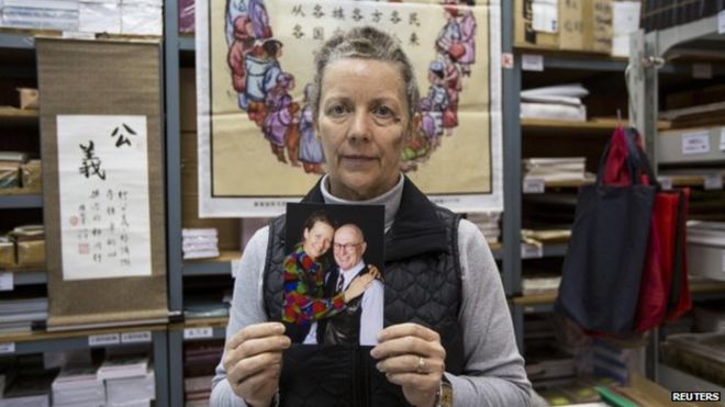 Карен Шорт, жена австралийского миссионера Джона Шорта, позирует с фотографией своего мужа в Христианской книжной комнате в Гонконге 20 февраля 2014 года