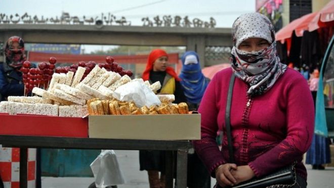 Фотография из файла уйгурских женщин, делающих покупки на базаре в китайском регионе Синьцзян