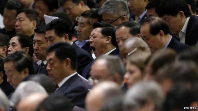 Делегат зевает, когда премьер-министр Китая Ли Кэцян выступает с докладом о работе правительства во время церемонии открытия Национального народного конгресса в Большом зале народных собраний в Пекине, 5 марта 2014 года. Китай возобновил свое обещание бороться с загрязнением воздуха, затрагивающим города