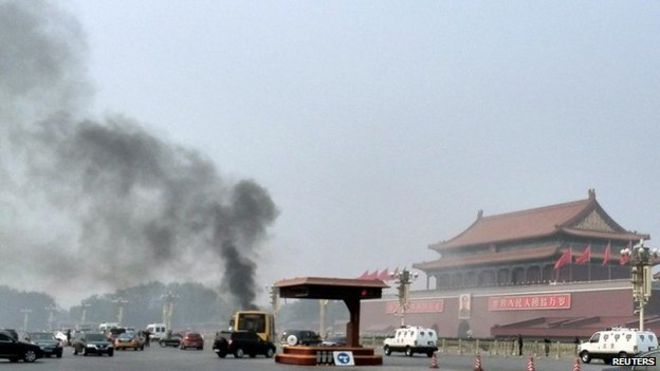 Автомашины едут по проспекту Чанъань, когда дым поднимается перед портретом покойного китайского председателя Мао Цзэдуна на площади Тяньаньмэнь в Пекине 28 октября 2013 года