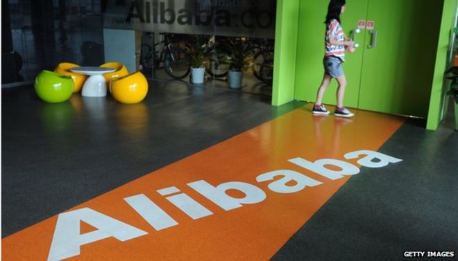 Логотип Alibaba на полу с женщиной