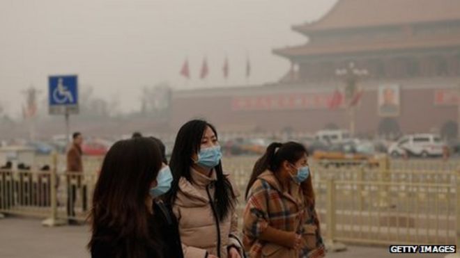 Три женщины в масках в Китае перед храмом