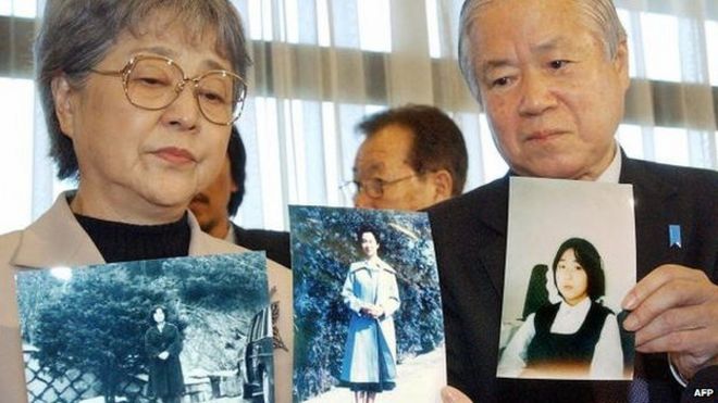 Сигеру и Саки Йокота показывают портреты своей дочери Мегуми на пресс-конференции в Токио 16 ноября 2004 года