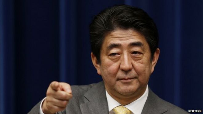 Премьер-министр Японии Синдзо Абэ указывает на репортера во время пресс-конференции в его официальной резиденции в Токио 10 марта 2014 года, за день до третьей годовщины землетрясения 11 марта 2011 года, цунами и ядерного кризиса, поразившего страны на северо-востоке