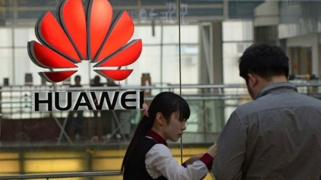 Сотрудник (слева) имеет дело с покупателем в магазине Huawei в Пекине 24 марта 2014 года.