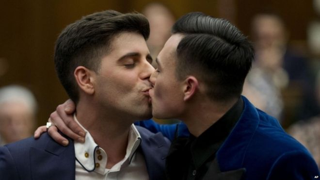 Двое мужчин целуются на гей-свадьбе