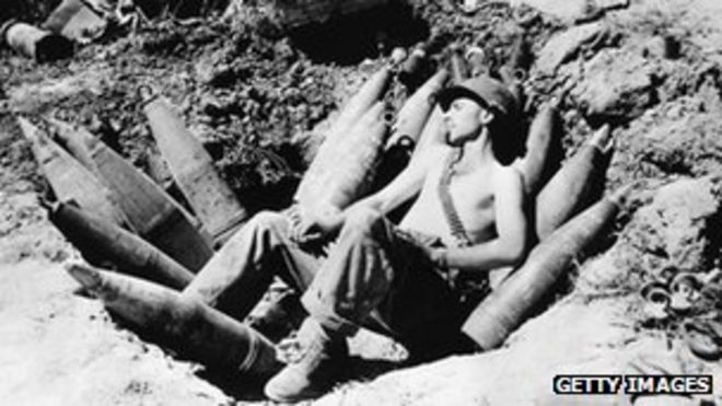 Американский солдат спит на своих боеприпасах во время корейской войны