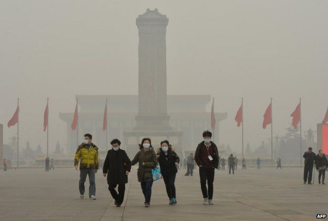 Китайские туристы носят лицевые маски во время посещения площади Тяньаньмэнь
