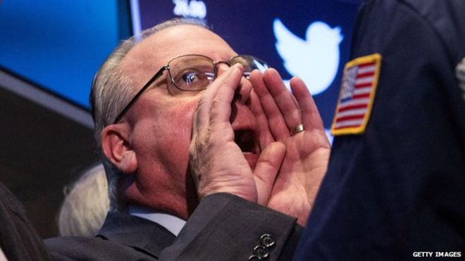 NYSE трейдер с логотипом Twitter за ним