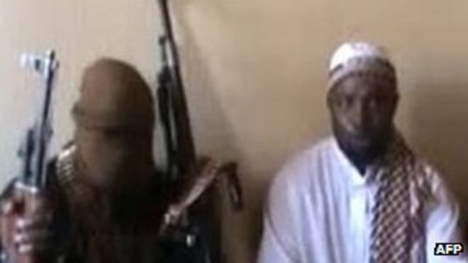 27338454Снимок экрана, снятый с видео, опубликованного на You Tube в апреле 2012 года, на котором видно, что лидер «Боко харам» Абубакар Шекау (в центре) сидит в окружении боевиков