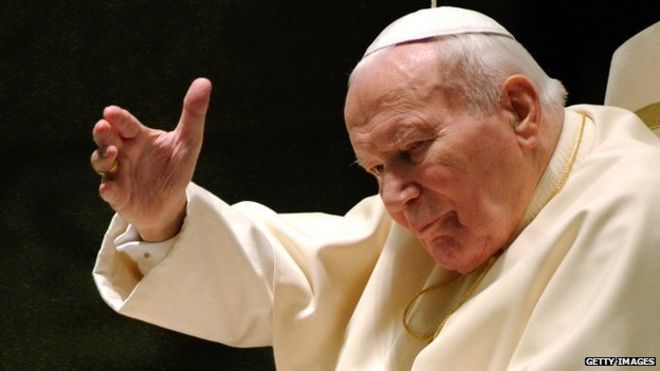 Папа Иоанн Павел II машет во время своей еженедельной аудиенции 17 декабря 2003 года в Ватикане.