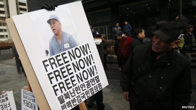 Протестующие против Северной Кореи держат плакат с изображением христианского миссионера США Кеннета Бэ в центре Сеула 16 февраля 2014 года.