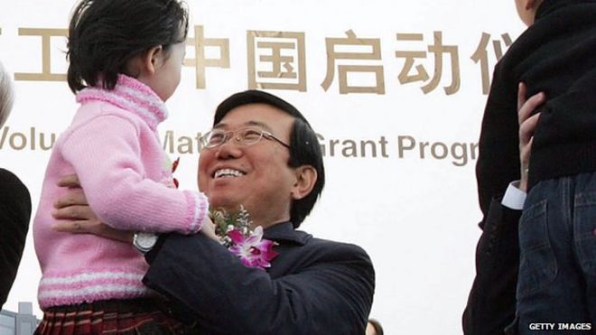 Ли Чуньчэн, секретарь Городского комитета КПК Чэнду, держит ребенка во время церемонии открытия сборочного и испытательного завода Intel в Чэнду, в западной зоне промышленного развития Чэнду 6 декабря 2005 года в Чэнду, провинция Сычуань, Китай