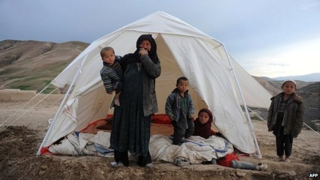 Афганская женщина с детьми стоит возле своей палатки на месте оползня в районе Арго в Бадахшане - 3 мая 2014 года