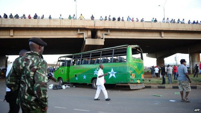 Солдат стоит на страже возле поврежденного автобуса после того, как два взрыва попали в два автобуса по дороге Тика в Найроби 4 мая 2014 года.
