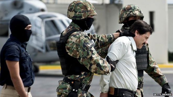 Мексиканского наркоторговца Хоакина Гусмана сопровождают морские пехотинцы, так как он представлен прессе 22 февраля 2014 года