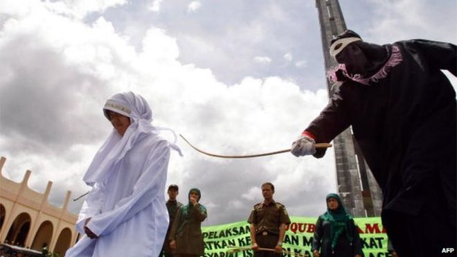 Фото из архива: Женщина находится под угрозой нарушения исламского закона шариата возле мечети в Джанто, провинция Ачех, Индонезия, 1 октября 2010 года