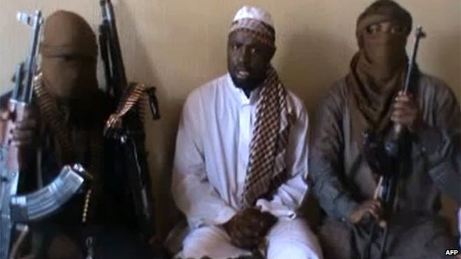 Снимок экрана, снятый из видео, опубликованного на You Tube 12 апреля 2012 года, по-видимому, показывает лидера «Боко харам» Абубакара Шекау (С), сидящего в окружении боевиков