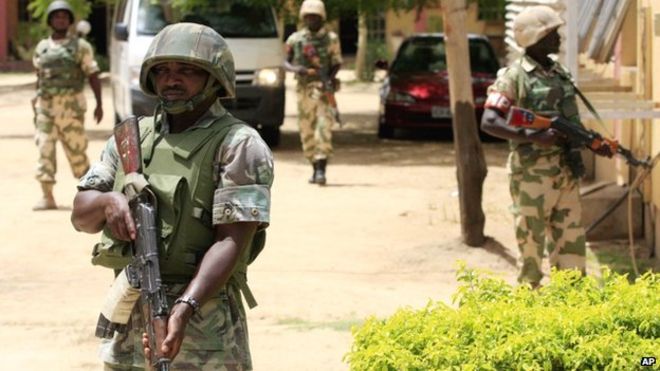 Нигерийские солдаты стоят на страже в офисах Государственного управления телевидения Нигерии в Майдугури, Нигерия - июнь 2013 г.