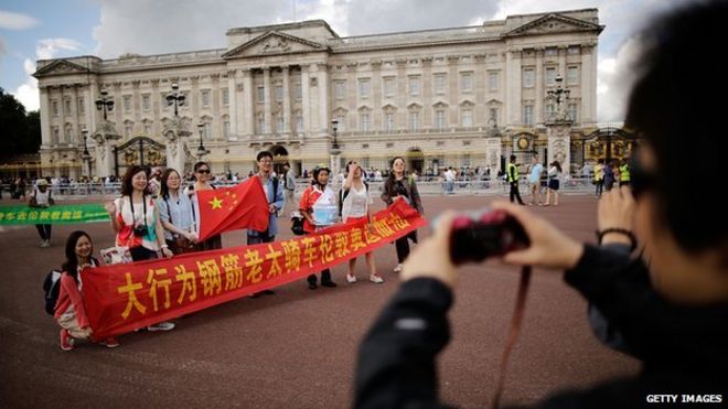 Китайские туристы сфотографировались возле Букингемского дворца 29 июля 2012 года в Лондоне, Англия