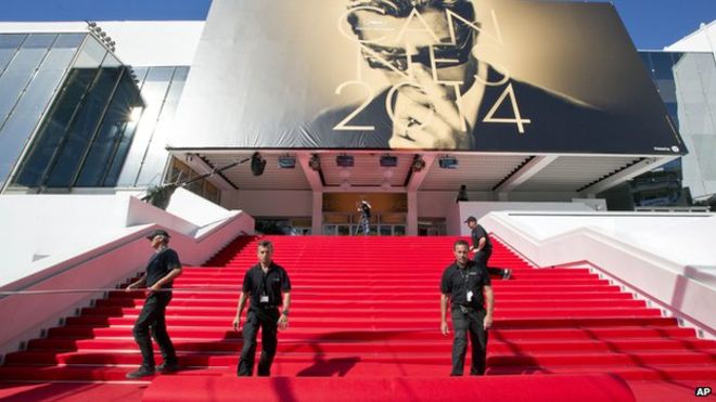 Рабочие готовят красную ковровую дорожку на лестнице Дворца фестивалей перед началом 67-го международного кинофестиваля в Каннах