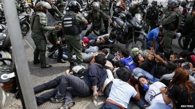 Полиция задержала группу антиправительственных демонстрантов во время акции протеста в Каракасе, 14 мая 2014 года.