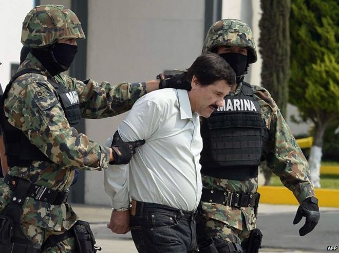 Мексиканский торговец наркотиками Хоакин Гусман Лоера, также известный как «эль Чапо Гусман» (С), сопровождается морскими пехотинцами, поскольку он представлен прессе 22 февраля 2014 года в Мехико