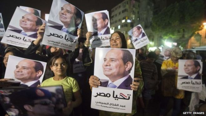 Сторонники г-на Сиси смотрят экран в Каире, демонстрирующий его первое телевизионное интервью