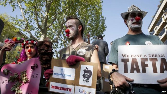 Демонстранты в костюмах клоунов принимают участие в митинге против трансатлантических торговых соглашений, Париж, апрель 2014 г.