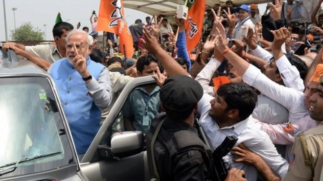 Премьер-министр избирает волны Нарендры Моди, когда он прибывает в международный аэропорт имени Индиры Ганди в Нью-Дели 17.05.2014