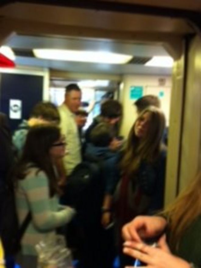 Пассажиры в поезде, проходящем через Колчестер около 08:30