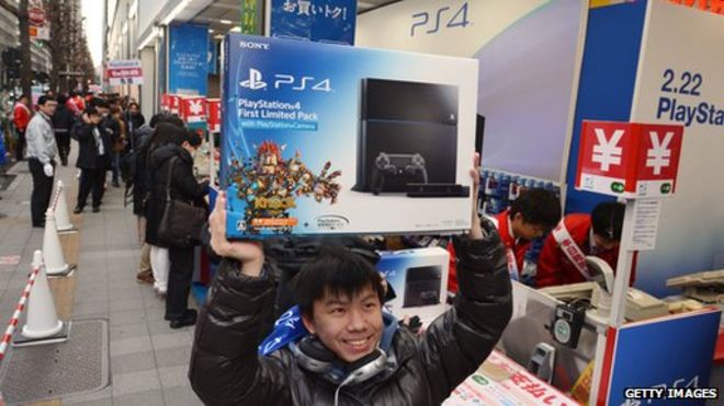Человек покупает PlayStation 4