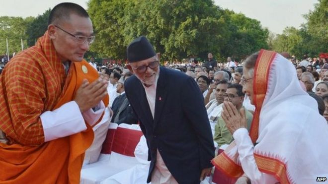 Премьер-министр Бутана Тшеринг Тобгай (слева) приветствует бывшего президента Индии Пратибху Патил (справа), а непальский премьер Сушил Койрала (слева) наблюдает за церемонией приведения к присяге премьер-министра Индии Нарендры Моди в Нью-Дели 26 мая 2014 года