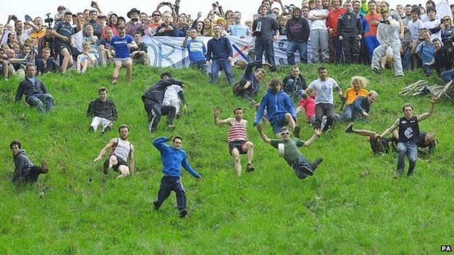 Конкуренты в гонке Cheese Rolling на Cooper's Hill возле Брокворта, графство Глостершир