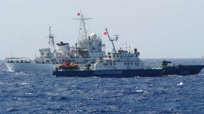 На этом снимке, сделанном 14 мая, показано, что китайский корабль береговой охраны (задний) плывет рядом с вьетнамским судном береговой охраны (передний край) у китайской нефтяной буровой установки в спорных водах в Южно-Китайском море.