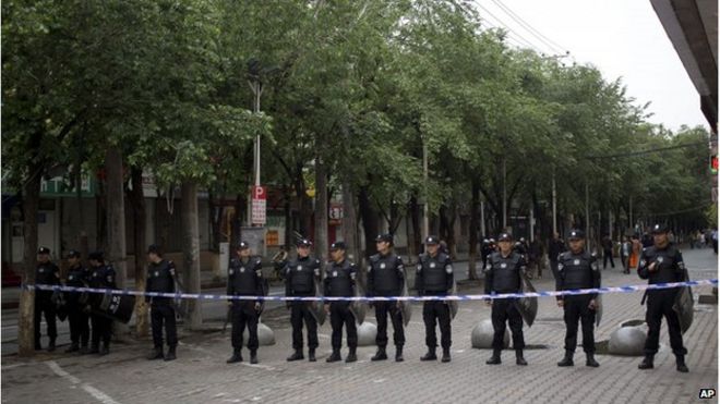 Полицейские стоят на страже у дороги, ведущей к месту взрыва в четверг в Урумчи, северо-западном регионе Китая, Синьцзяне, в пятницу, 23 мая.