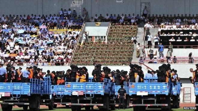 Грузовики с преступниками и подозреваемыми видны во время массового митинга на стадионе в городе Или, Синьцзян-Уйгурский автономный район, 27 мая 2014 года