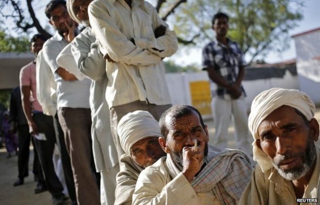 Мужчины-мусульмане, которые были перемещены в результате смертельной религиозной розни в прошлом году, ждут, чтобы отдать свой голос за всеобщие выборы возле избирательного участка в деревне Парла в районе Музаффарнагар