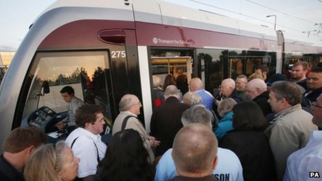 Люди в очереди, чтобы сесть на трамвай в Эдинбурге