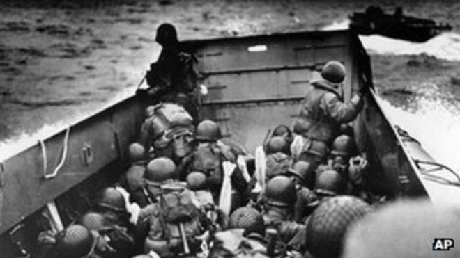 Посадочная баржа, плотно укомплектованная солдатами в шлемах, приближается к берегу в Нормандии, Франция, в день Д.
