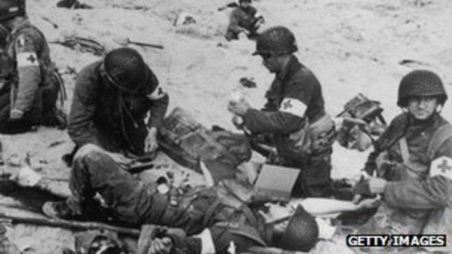 Американские медики оказывают первую помощь раненым солдатам на пляже Юта в Нормандии, Франция, 6 июня 1944 года