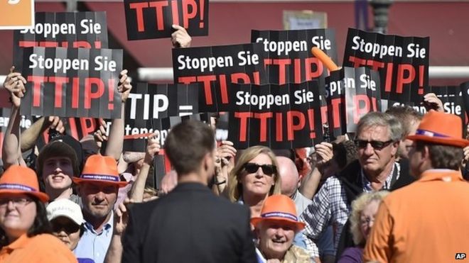 Люди протестуют против Трансатлантического торгового и инвестиционного партнерства (ТТИП) с США на заключительной избирательной партии Христианско-демократического союза 23 мая 2014 года