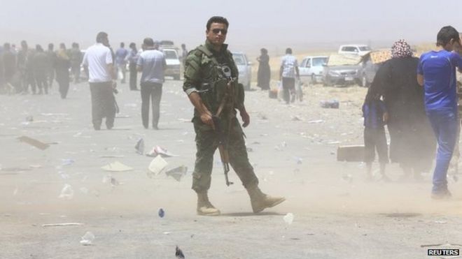 Сотрудник курдских сил безопасности стоит на страже на контрольно-пропускном пункте на окраине Эрбиля (10 июня 2014 года)