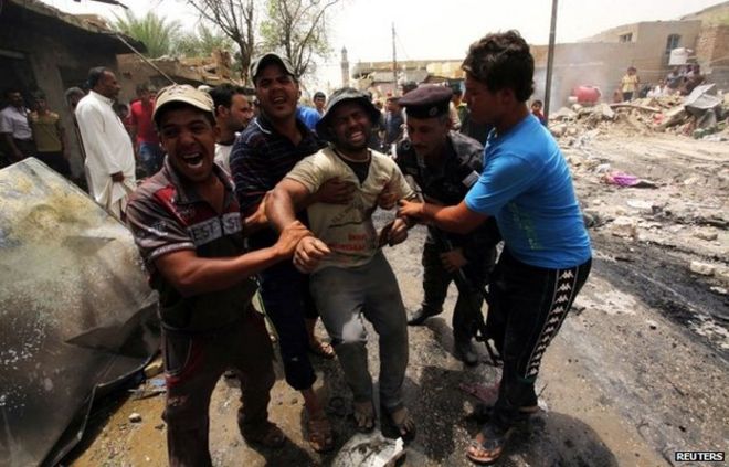 Последствия взрыва автомобильной бомбы на рынке в городе Искандария, к югу от Багдада (2 июня 2014 года)