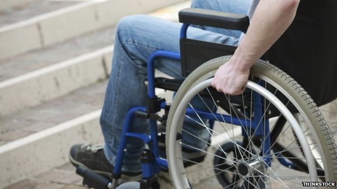 Человек в инвалидной коляске у подножия лестницы