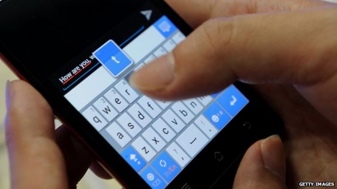 Человек, использующий клавиатуру сенсорного экрана мобильного телефона, чтобы написать текстовое сообщение